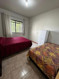 a bedroom with two beds and a window at Casa ampla de 4 quartos in Piratuba