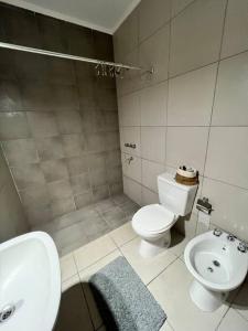 a bathroom with a sink and a toilet and a bidet at Departamento en Esperanza in Esperanza +6 photos
