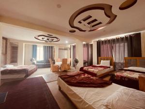 um quarto com duas camas e uma sala de estar em Mount View Hotel Skardu em Skardu