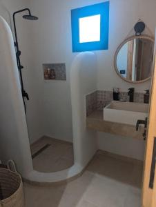 a bathroom with a sink and a mirror at Dar Bärjel in Djerba +7 photos
