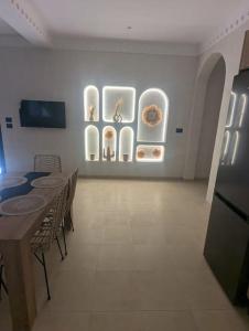 a room with a table and some plates on a wall at Dar Bärjel in Djerba