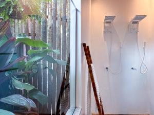 een badkamer met een douche en een raam met een plant bij Aqualtune Pousada in Barra Grande