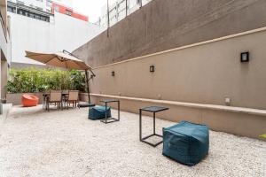um pátio com uma mesa e um guarda-sol em Next Paulista by Viva - Apartamentos completos ao lado da Av Paulista e MASP em São Paulo mais 198 fotografias