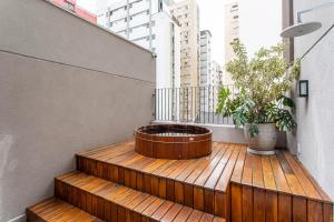a wooden deck with a potted plant on a balcony at Next Paulista by Viva - Apartamentos completos ao lado da Av Paulista e MASP in São Paulo