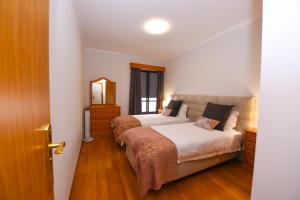 a bedroom with two beds and a mirror at Farinha's Apartment in Ribeira Brava