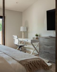 Un dormitorio con un escritorio, una silla y un televisor. en Riviera - Lazy River Pool, Pickleball, Game Room!, en Bermuda Dunes