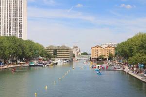 a river in a city with boats on it at Chambre à Montmartre Atelier architecte in Paris
