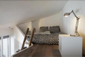 a bedroom with a bed and a staircase with a lamp at Chambre à Montmartre Atelier architecte in Paris