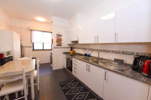a kitchen with white cabinets and a counter top at Farinha's Apartment in Ribeira Brava