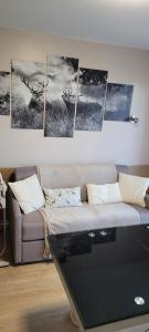a living room with a couch and some paintings on the wall at Le Petit Sapin in Xonrupt-Longemer +22 photos