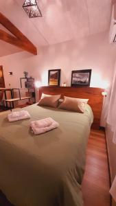 a bedroom with a large bed with two towels on it at Casa en la Montaña, Casa Chucao in El Bolsón +55 photos