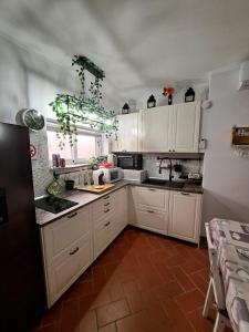 a kitchen with white cabinets and a tile floor at IlMareaDuePassi Guest House in Rosignano Solvay