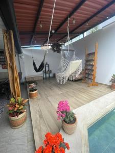 een patio met een hangmat, bloemen en een zwembad bij Hostal los profes in Mocoa
