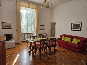 a living room with a table and a red couch at Appartamento incantevole con loggia sui tetti in Siena