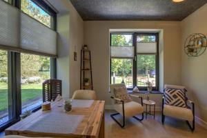 a dining room with windows and a table and chairs at B&B Doraki in Oldebroek