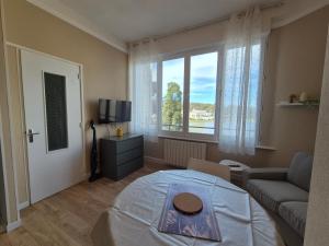 a living room with a large window and a couch at Studio face au lac in Bagnoles de l'Orne