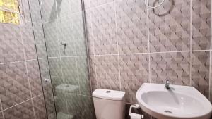 a bathroom with a shower and a toilet and a sink at Cabana Cristal ll Campestre Em Sítio ll Wi-Fi Nômade Digital ll Táxi Fácil II Forno Microondas ll Quiosque Churrasqueira ll 6km da Estrada do Mar ll 8,1Km Prefeitura II 7,2Km UFRGS Litoral II 12km do Morro da Borrusia e das Praias Tramandai in Osório +9 photos