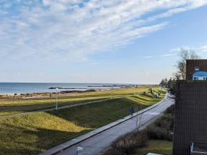a person walking down a road next to the beach at Comfortable holiday home in nature in Schönberg