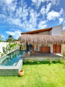 a villa with a swimming pool and a house at Villa Mar Milagres - bangalôs de luxo em São Miguel dos Milagres, Alagoas in São Miguel dos Milagres