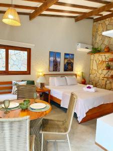 a bedroom with two beds and a table and chairs at Villa Mar Milagres - bangalôs de luxo em São Miguel dos Milagres, Alagoas in São Miguel dos Milagres