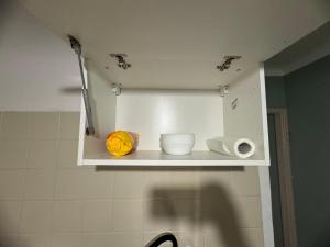 a white cabinet in a bathroom with some dishes on it at Mieszkaj u Marty stale na Stałym in Jaworzno +27 photos