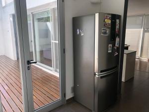 a stainless steel refrigerator in a room with a wooden floor at Andrade1251 in Mar del Plata