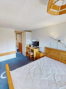 a bedroom with a bed and a desk with a computer at Duplex arcs 1800 aux pieds des pistes in Arc 1800