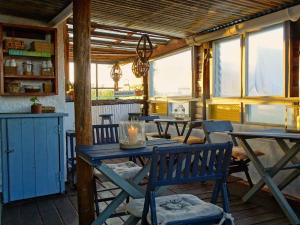 a dining room with tables and chairs and windows at Carmela Suites Cabo Polonio in Cabo Polonio