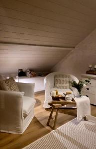 un salon avec un canapé blanc et une table dans l'établissement L'écrin, charmant cottage aux portes de la cité médiévale de Semur-en-Auxois, à Chevigny 26 autres photos