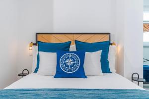 a bed with blue and white pillows on it at Varanda Azul - Lookout Loft (City Centre) in Ponta Delgada