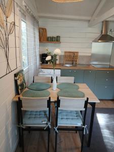 a kitchen with a wooden table with chairs and a table and a table at Chez Eve 2 in Nîmes