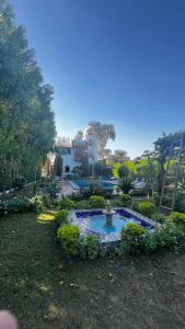 a garden with a fountain in front of a house at Villa Barba Luxor in Luxor