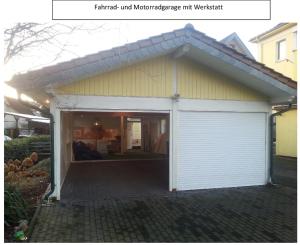 eine Garage mit einer weißen Garagentür in einem Haus in der Unterkunft Hotel zur Sportsbar in Horn-Bad Meinberg