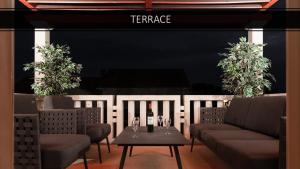 - une terrasse avec des chaises et une table avec une bouteille de vin dans l'établissement APARTMENTS4YOU SUPETAR 5 - brand NEW luxury 2-BR - 200 meters from the beach - free parking - beautiful terrace, à Supetar