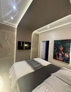 ein Schlafzimmer mit einem Bett und einem Gemälde an der Wand in der Unterkunft La Vela Luxury in Trogir