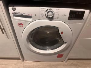 a washing machine with its door open in a kitchen at Secluded cosy extension with free parking, sleeps 4 in Blackwater