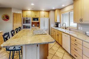 a kitchen with wooden cabinets and a large counter top at Dogleg Retreat in Sunriver