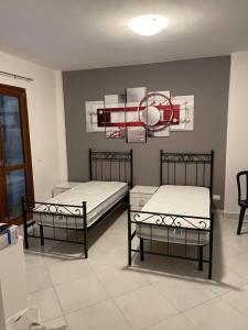a room with two beds and a basketball hoop on the wall at Affitta Camere DA MARIA 1 in Albiano