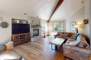 a living room with a couch and a tv at Dogleg Retreat in Sunriver