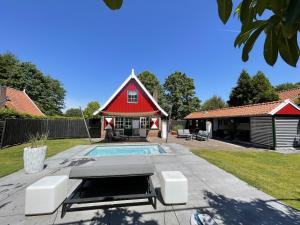 a house with a pool and a red barn at De Madelief 6-persoons in Lievelde