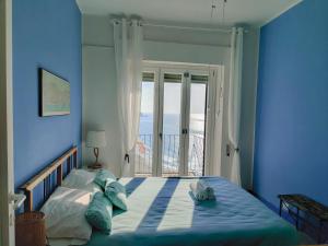 a blue bedroom with a bed with a view of the ocean at CasaAzul in Sperlonga