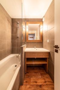 Le Mirador - Immodreams - Avoriaz في أفورياز: حمام مع حوض وحوض استحمام ومرآة
