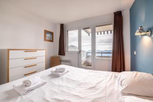 Le Mirador - Immodreams - Avoriaz في أفورياز: غرفة نوم بسرير أبيض ونافذة