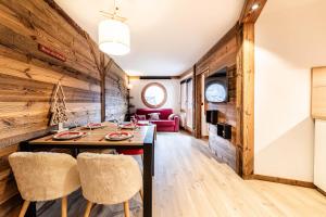 a living room with a wooden wall and a table and chairs at L Elinka - Immodreams - Avoriaz in Avoriaz