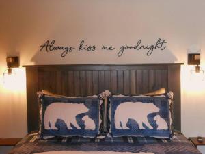 a bedroom with a bed with a sign that reads always kiss me graduated at Tiny Bear in Sevierville