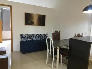 a living room with a table and a blue couch at VieiraNunes Flats in Rio de Janeiro +5 photos