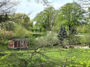 a garden with a red box in the grass at Kuscheltage im Zirkuswagen am Kanal im Münsterland in Recke