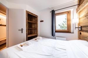 a bedroom with a large white bed and a window at L Elinka - Immodreams - Avoriaz in Avoriaz