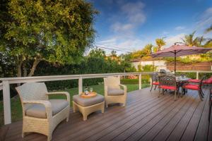 une terrasse avec des chaises, une table et un parasol dans l'établissement Las Palmas Escape, à San Diego