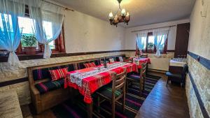 a restaurant with two tables and chairs and windows at Родопска къща за гости с.ЧАЛА in Chala